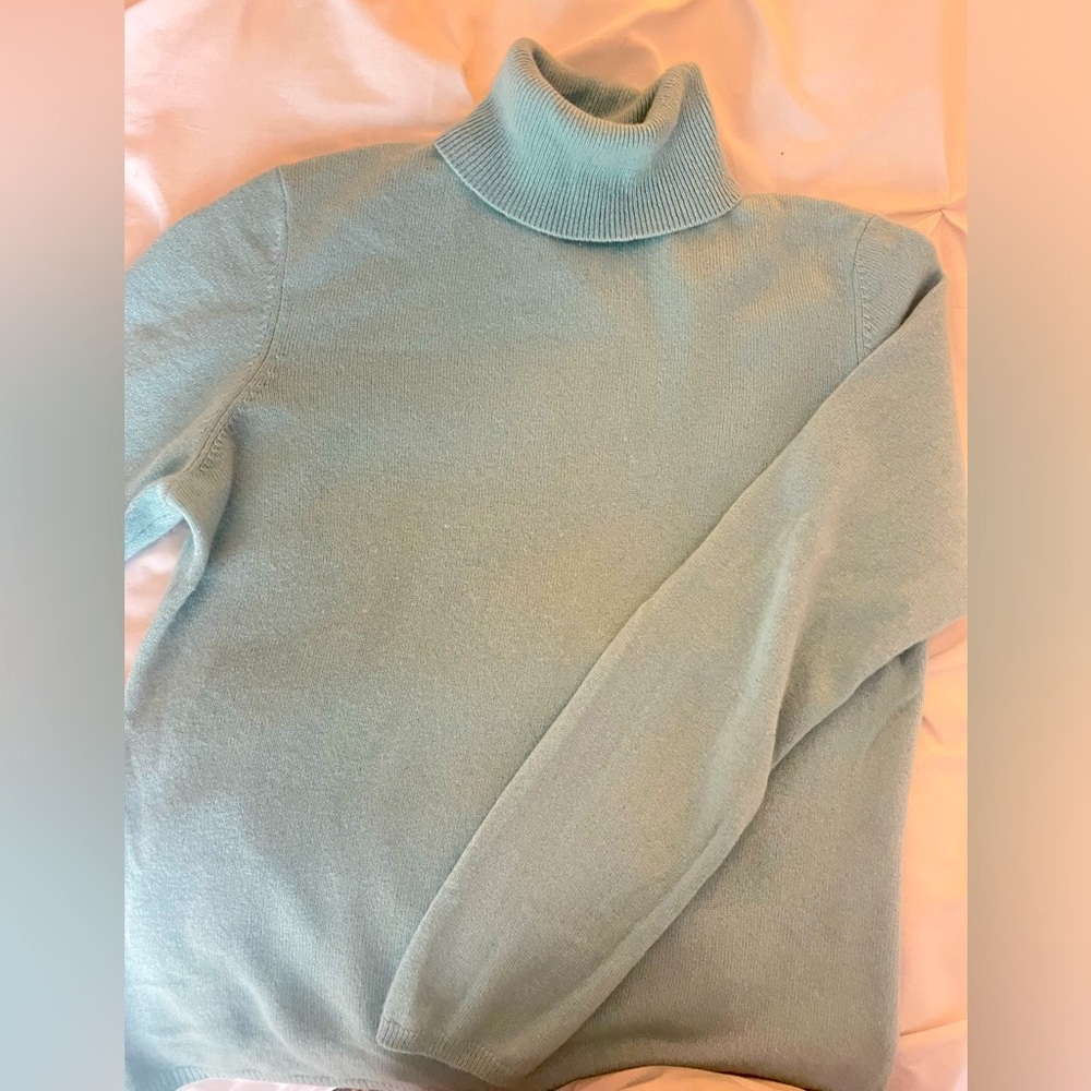 This is a cozy, light blue turtleneck sweater.